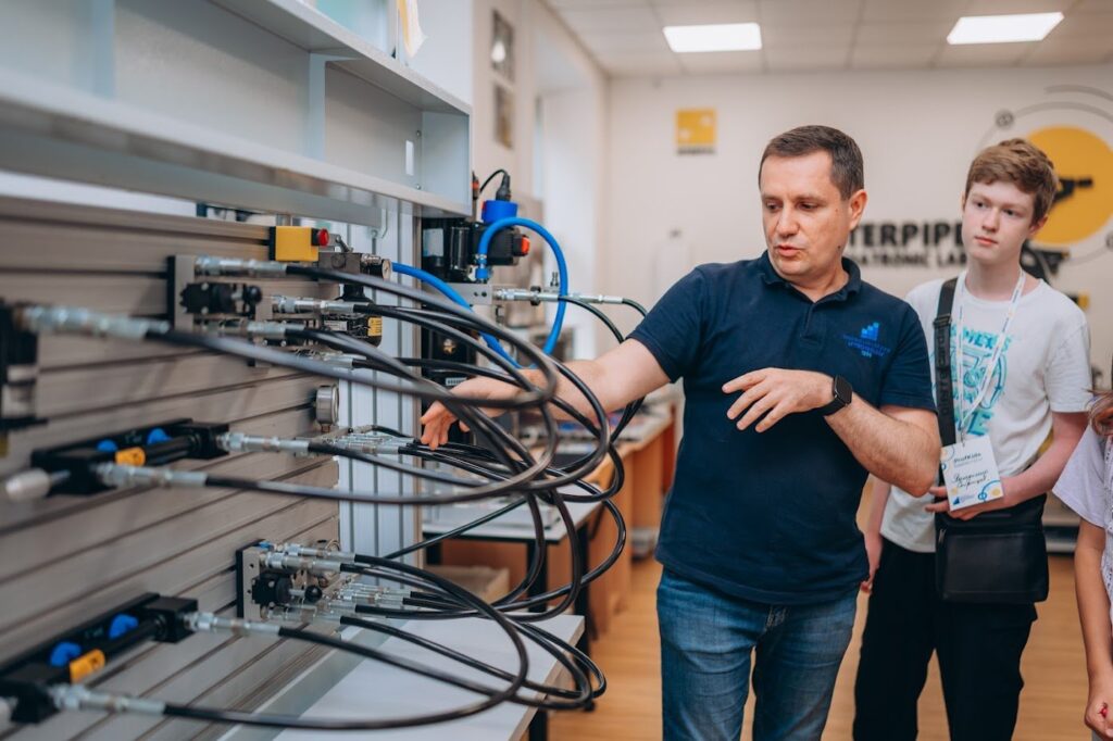 Мехатронна лабораторія Interpipe: фахівець показує відвідувачам навчальний стенд